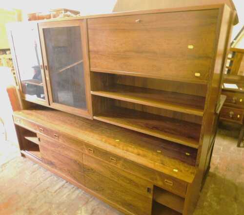 A simulated wood veneer room lounge unit, with an arrangement of glass fronted doors, cupboards,...