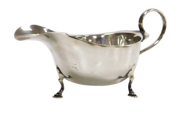 A George V silver sauceboat, with a scroll handle, raised on three hoof feet, Birmingham 1925, 2....