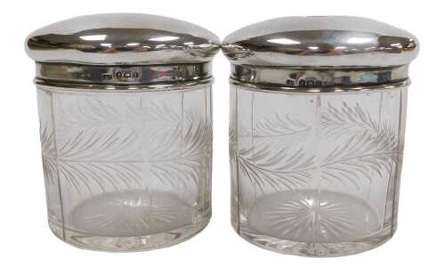 Two George V cut glass and silver lidded toilet jars, engraved with a band of leaves, Birmingham...