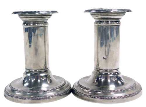 A pair of Edward VII loaded silver candlesticks, with beaded decoration, London 1907, 15.90oz...
