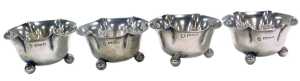 A set of four Edward VII silver salts, of flowerhead form, each raised on three ball feet,...