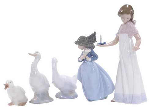 A Nao porcelain figure of a girl holding a chamber stick, another girl with a cornet of flowers,...