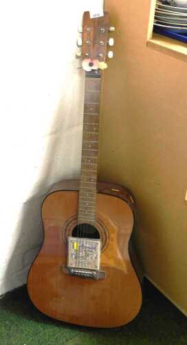 An acoustic guitar, together with Earth Wood bronze acoustic strings and plectrums.