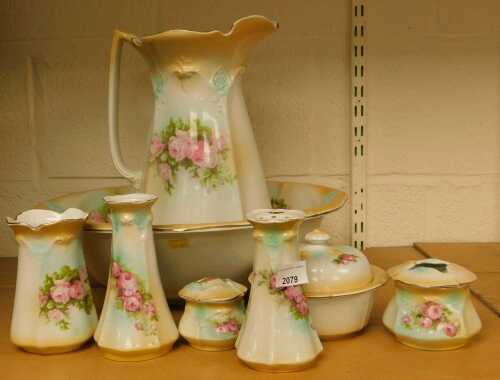 An early 20thC wash set, to include a water jug and bowl, toothbrush holder, various jars, etc,...