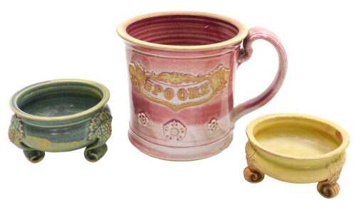 A Martin Homer pottery tankard, with a red glaze, with applied floral decoration and a banner...