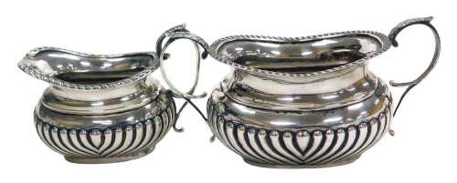 A Victorian silver semi fluted cream jug, Sheffield 1900, and a semi fluted twin handled sugar...