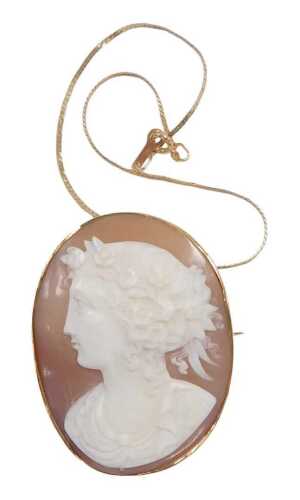 A shell cameo brooch, bust portrait of a lady facing left, with flowers in her hair, in a yellow...