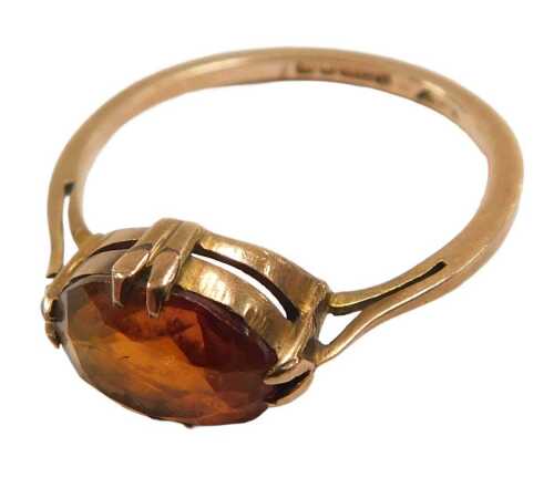 A 9ct gold solitaire ring, set with an oval cut orange stone, size Q, 1.9g.