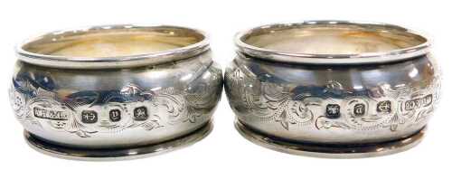 A pair of Victorian silver napkin rings, with foliate engraved decoration, shield reserves,...