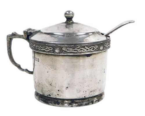 An Elizabeth II silver three piece condiment set, with Celtic banded decoration, the mustard pot...