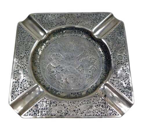An early 20thC Eastern ashtray, embossed with birds, flowers and scrolling leaves, white metal,...