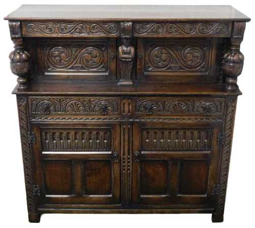 A 17thC style oak court cupboard, with an acanthus leaf carved frieze above two panelled doors,...