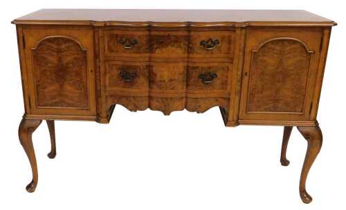 An early 20thC burr walnut and walnut crossbanded serpentine fronted sideboard, with two frieze...