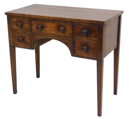 An early 19thC mahogany kneehole desk, with one medium flanked by four short drawers, raised on...