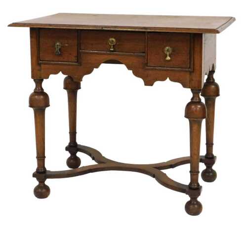 A 17thC style oak lowboy, with one short flanked by two deep drawers, above a shaped apron,...