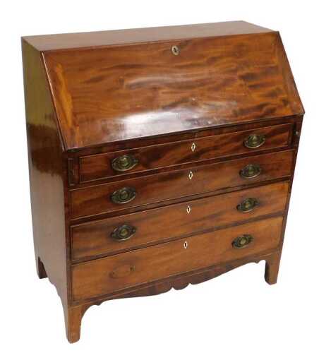 A George III mahogany bureau, the fall flap opening to reveal an arrangement of six drawers and...