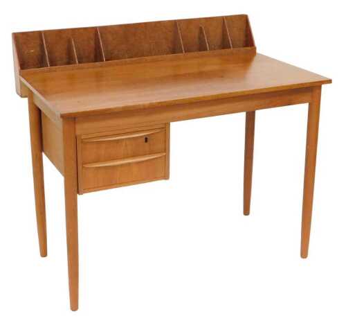 A mid century teak clerk's desk, the back with seven recesses, with two floating drawers, raised...