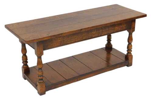 A Jacobean style oak coffee table, the rectangular three plank top raised on turned legs, united...