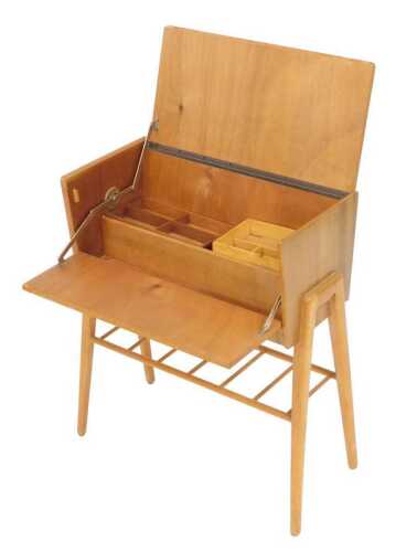 A mid century walnut sewing box, with a cantilever lid and fall, opening to reveal a fitted...