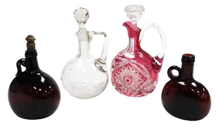 A Bohemian cranberry cut glass claret jug, with a clear glass stopper, 26cm high, further clear...