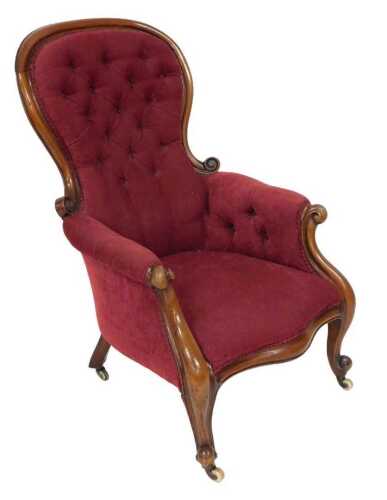 A Victorian mahogany balloon back nursing chair, upholstered in red button back draylon, raised...