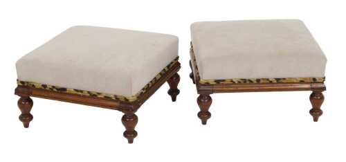 A pair of Victorian mahogany footstools, upholstered in mushroom coloured suede fabric, raised...
