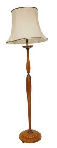 An early 20thC light mahogany standard lamp, of turned and fluted form, raised on a circular...