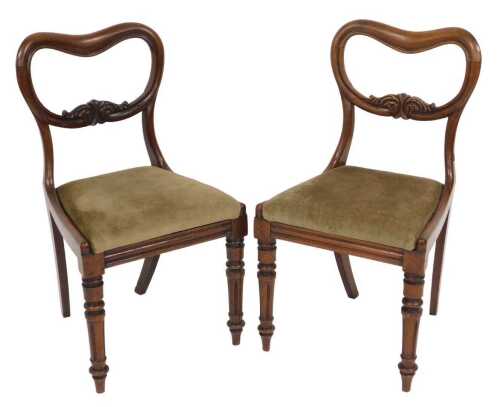 A pair of early Victorian mahogany balloon back dining chairs, with drop in seats, raised on...