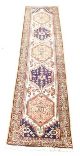 A Meshkin cream and blue ground runner, the central field decorated with five medallions,...