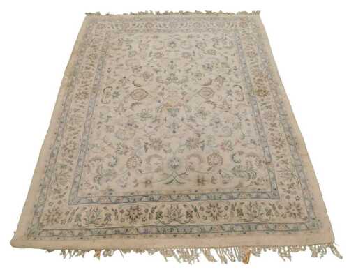 An Indian wool cream ground rug, decorated with flowers and scrolling leaves, 281cm x 222cm.