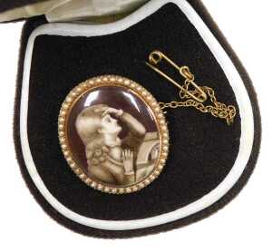 An early 19thC brooch, painted en grisailles, with a man seated by a book in contemplation, in a...