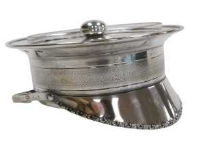 A WWI period silver plate and cut glass dish and cover, formed as a officer's peaked cap, with...