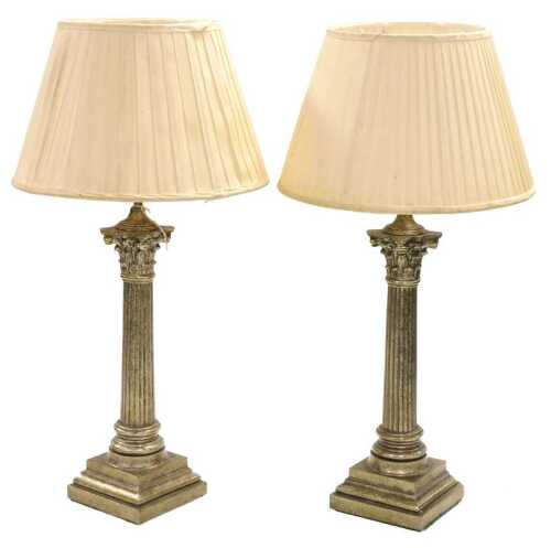 A pair of patinated metal Corinthian column table lamps, with pleated silk shades, 70.5cm high.