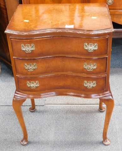A small walnut chest of drawers, the shaped top with a moulded edge above three drawers, on...