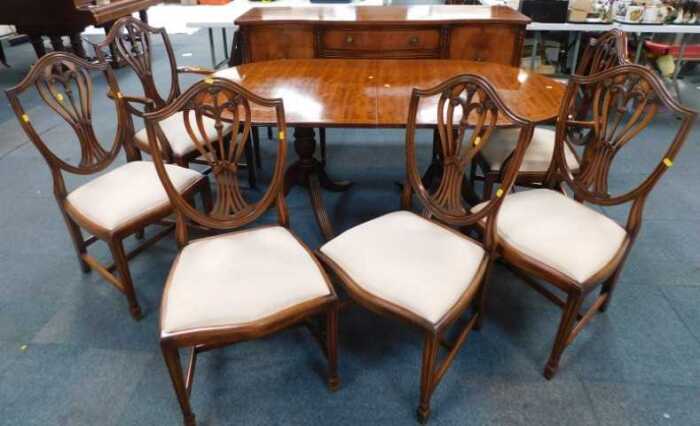 A mahogany dining suite, comprising a serpentine fronted sideboard, an extending dining table...