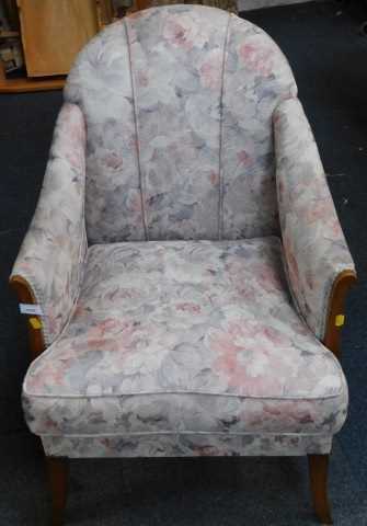 A floral upholstered beech armchair, on splayed legs.