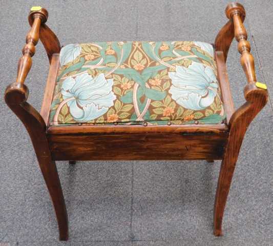 An Edwardian beech piano stool, with a hinged padded seat, on splayed legs.