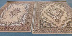 Two floral patterned Eastern style machine woven rugs, in brown and beige.