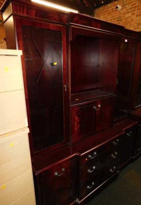 A mahogany veneered display cabinet, with two glazed doors flanked fall front, above base unit...