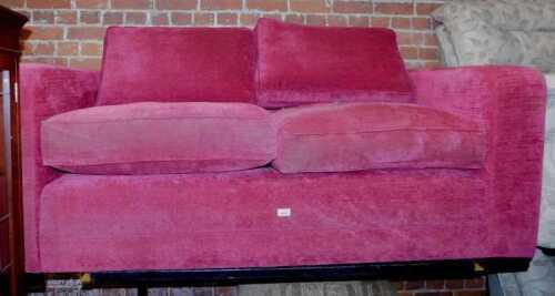 A red upholstered two seater sofa by Delcor.