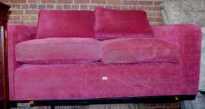 A red upholstered two seater sofa by Delcor.