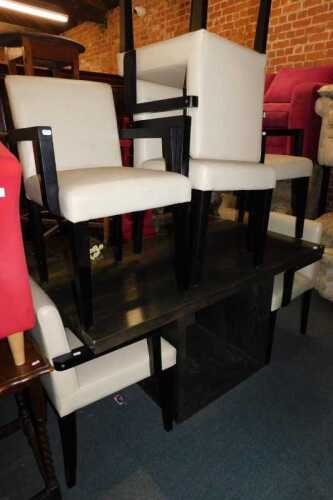 A modern dining suite, comprising a dining table, with a wood effect top, raised on black square...