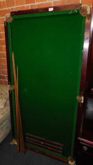A quarter size tabletop snooker table, with cues and scoreboard.