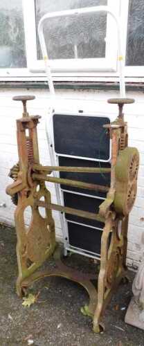 A cast iron mangle with horseshoe motif (AF), and a pair of steps, finished in white. (2)