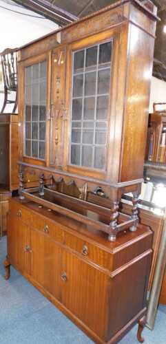 An oak bookcase, with two leaded glazed doors, on spirally turned supports, 118cm wide, and a...