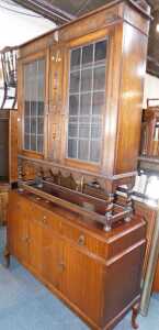 An oak bookcase, with two leaded glazed doors, on spirally turned supports, 118cm wide, and a...