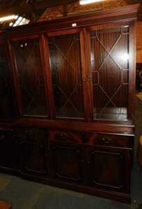 A Georgian style mahogany veneered display cabinet, of three astragal glazed doors over three...