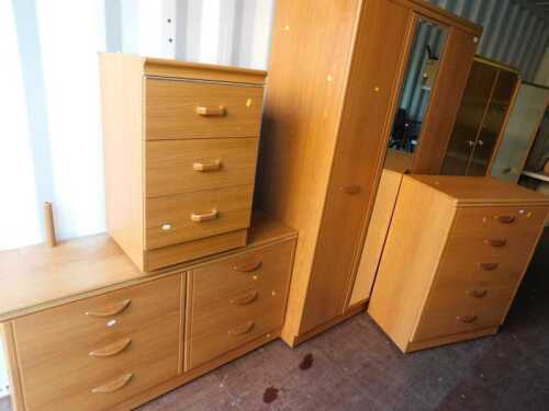 An oak laminate four-piece bedroom suite, comprising a double wardrobe with a mirrored door,...