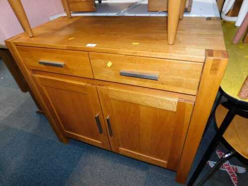 A light oak cupboard, with a pair of drawers over a pair of cupboard doors, raised on stiles,...