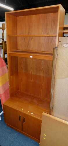 A G-Plan teak cupboard bookcase, with two shelves over a pair of cupboard doors, raised on...
